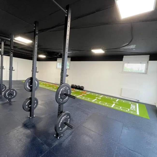 Conception d'un espace de préparation physique sur mesure en Suisse avec pelouse artificielle et matériel de pliométrie par Fitspro Équipement.