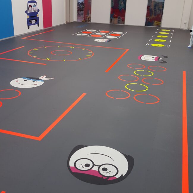 Revêtement de sol amortissant et ludique avec marquages interactifs pour zone de jeux et fitness enfants, installé par Fitspro Équipement.